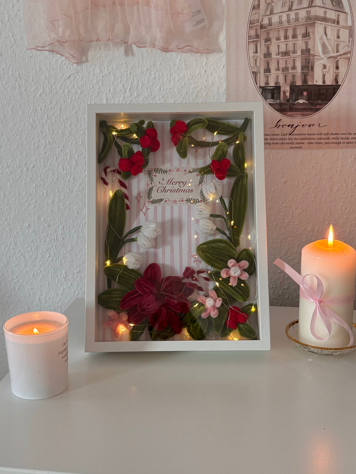 Red, dark red, pink and white pipe cleaner flowers in a Christmas frame
